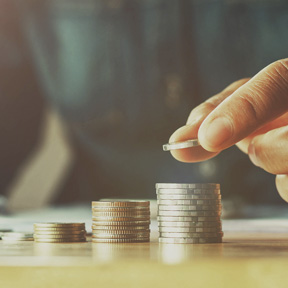 man stacking coins in piles